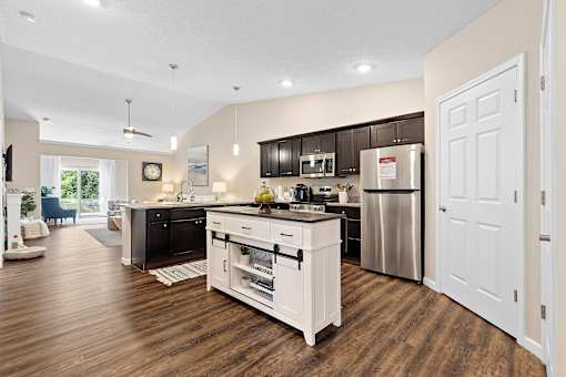 A modern kitchen with dark brown cabinets and white appliances.