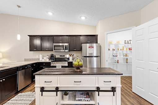 A kitchen with a black countertop and white cabinets.