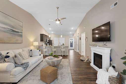 A living room with a white couch and a fireplace.