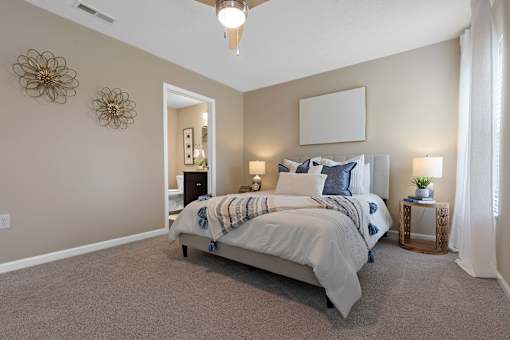 A bedroom with a large bed and a ceiling fan.