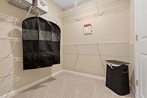 A room with a closet and a trash bin.