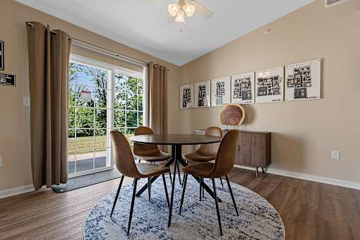 A dining room with a table and chairs.