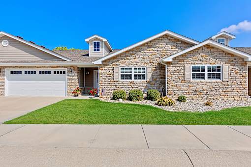 A house with a stone facade and a grey roof.