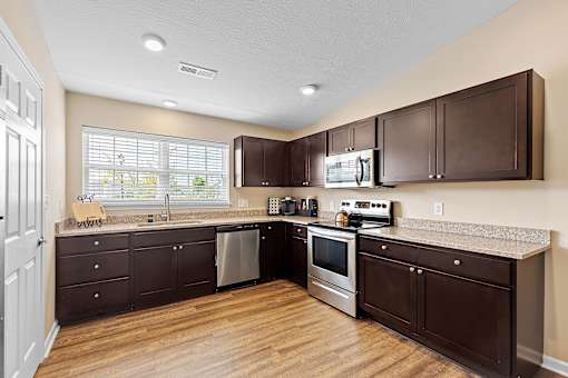 A kitchen with brown cabinets and stainless steel appliances.