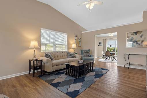 A living room with a couch, a table, and a rug.