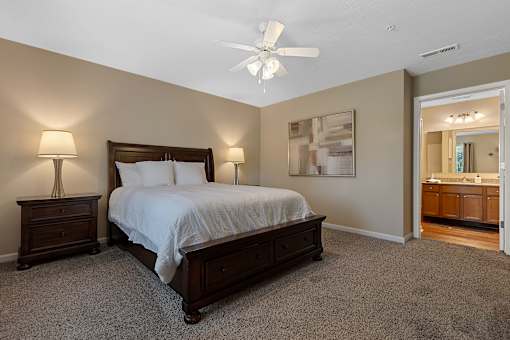 A bedroom with a bed, nightstands, and a ceiling fan.