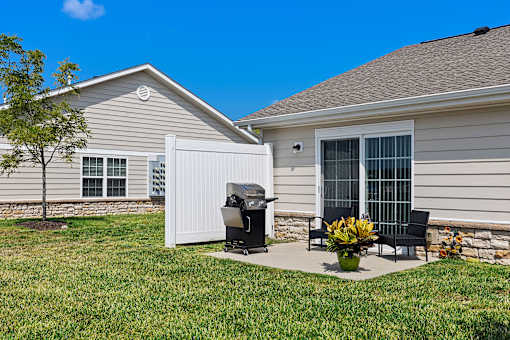 A house with a white grill and a black chair.