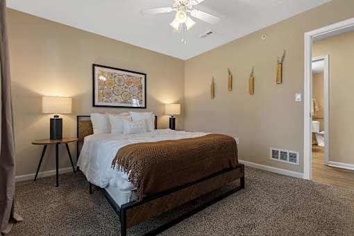 A bedroom with a large bed and a ceiling fan.