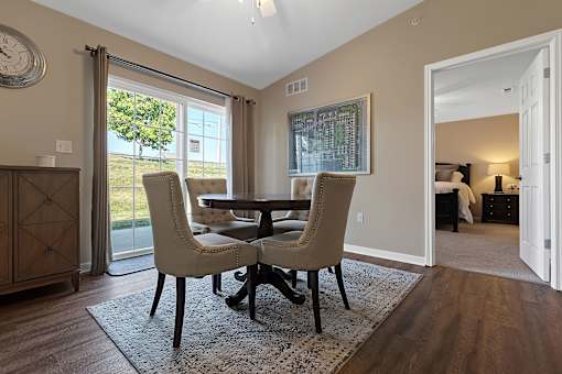 A dining room with a table and chairs.