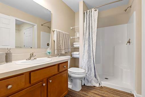 A bathroom with a toilet, sink, and shower.