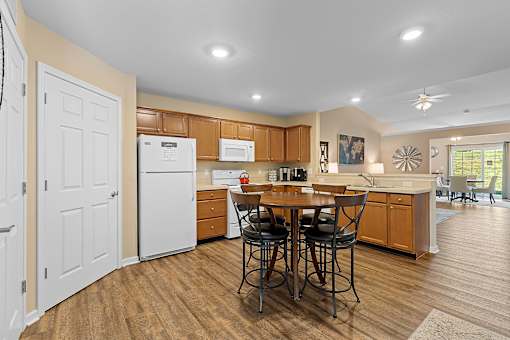 A kitchen with a table and chairs in the middle of the room.