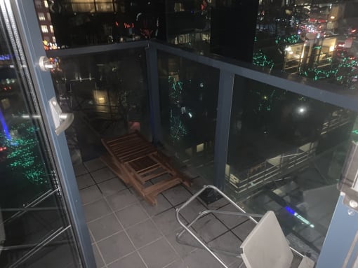 a folding chair on a balcony with a view of the city at night