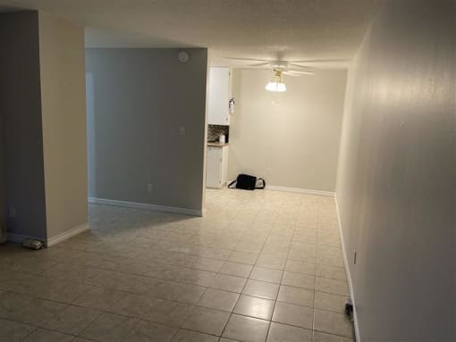 an empty living room with a tile floor