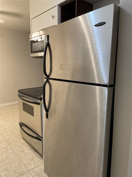 a stainless steel refrigerator and a microwave in a kitchen