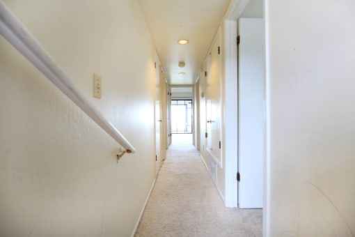 a hallway with white walls and white railings