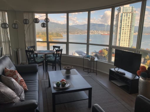 a living room with a large window and a view of a body of water