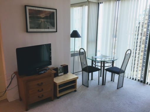 a living room and dining room with a table and chairs and a television