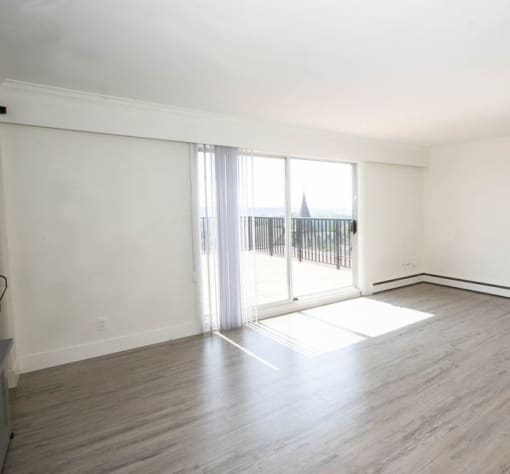 an empty living room with sliding glass doors to a balcony
