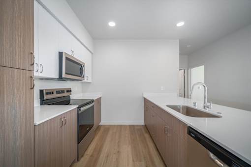 A modern kitchen with wooden cabinets and stainless steel appliances.