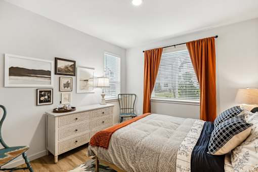 a bedroom with a bed and a dresser and a window