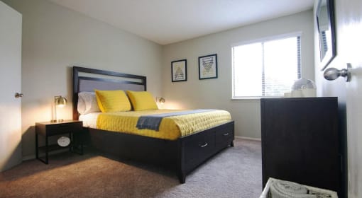 a bedroom with a bed and a dresser and a window