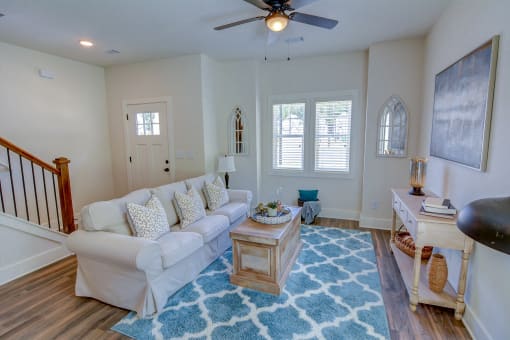 a living room with a white couch and a blue rug