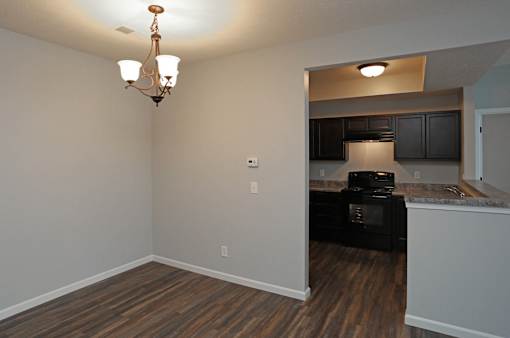 A kitchen area with a black oven and cabinets.