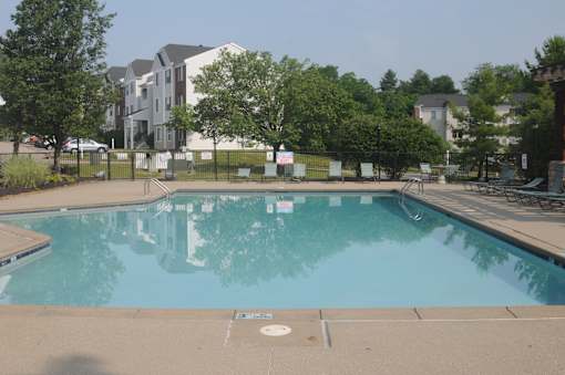 A large swimming pool with a building in the background.