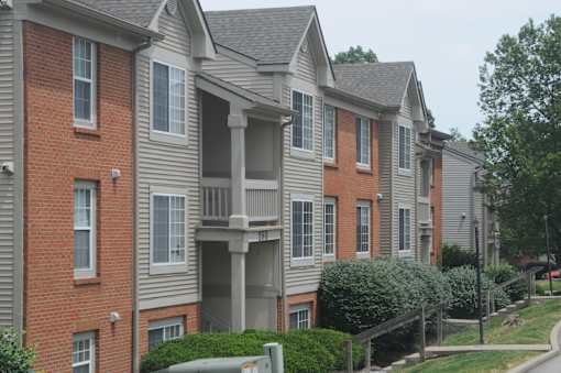 Apartment building with a red brick facade and a grey siding.