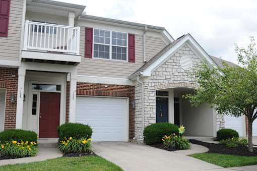 A house with a red door and a white garage door at The Legends at Steeplechase Apartments, Richwood, KY