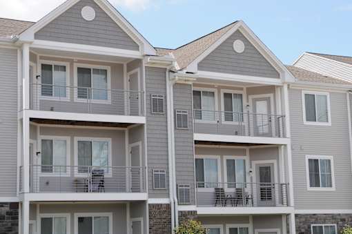 Apartment building with balconies and multiple windows.