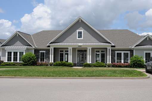 A house with a grey roof and a white car parked in front.