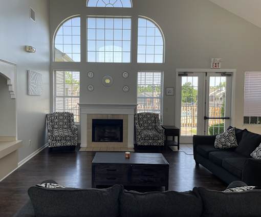 A living room with a fireplace and two chairs.