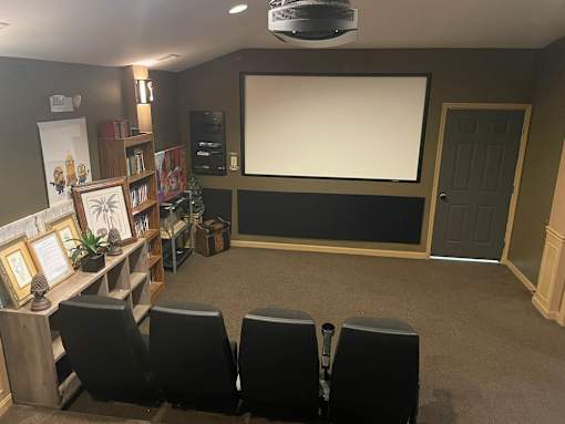 A home theater setup with a large screen and seating for four.