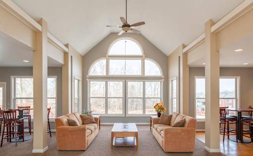 A living room with a large window and a ceiling fan.