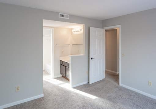 A small, empty room with a white door and a window.