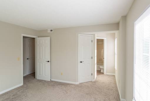 A room with two doors and a carpeted floor.