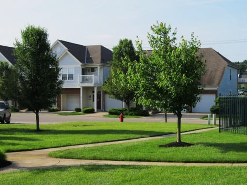 A tree in front of a house with a red fire hydrant in the front yard. at Twin Fountains Apartments, Ohio