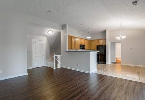 A spacious living room with a kitchen area in the background at Twin Fountains Apartments, Mason, OH, 45040