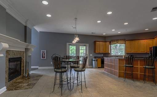 A kitchen with a table and chairs in front of a fireplace at Twin Fountains Apartments, Mason, Ohio
