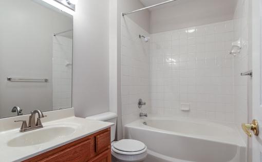 A white bathroom with a toilet, sink, and bathtub at Twin Fountains Apartments, OH, 45040