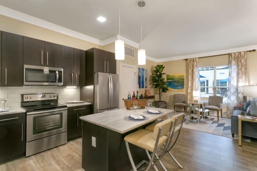 a kitchen with stainless steel appliances and a marble counter top at Aster Apartments, Beachwood, OH 44122