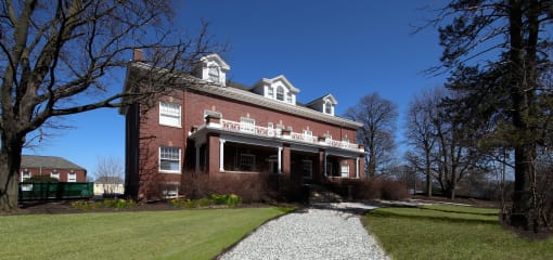 a red brick house with a white balcony and a walkway