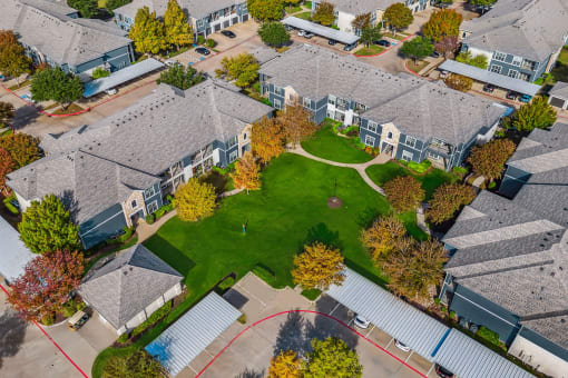 Aerial view of a neighborhood with houses and a green lawn at Riachi at One21, Texas, 75025