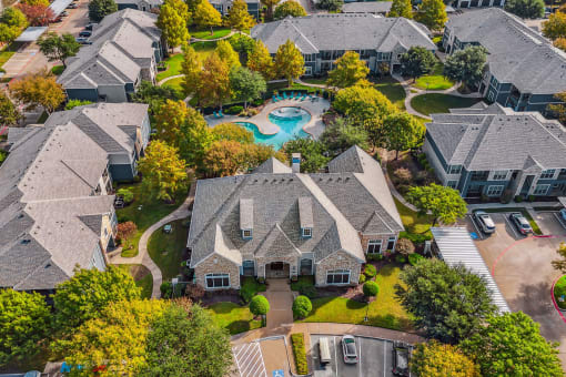 Aerial view of a neighborhood with houses and a swimming pool at Riachi at One21, Plano