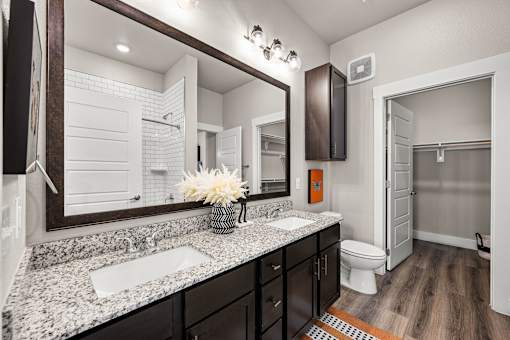 A bathroom with a sink, mirror, and toilet.