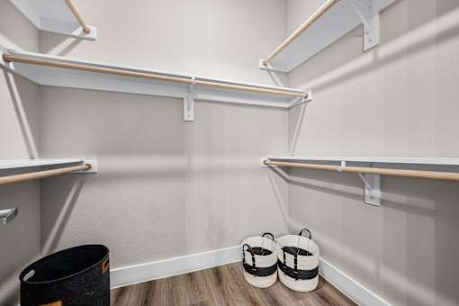 A room with a white wall and a black trash can.