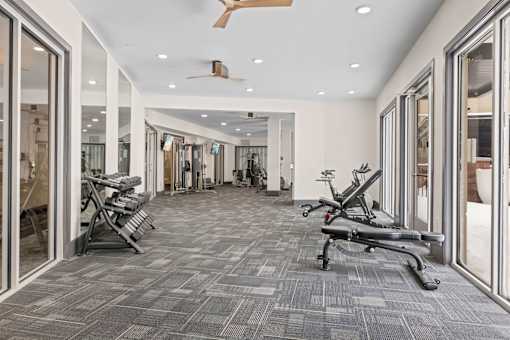 A gym with a grey carpet and a fan on the ceiling at Aster Apartments, Beachwood, OH 44122