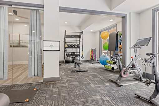 A gym with a variety of equipment including a treadmill, exercise balls, and a stationary bike at Aster Apartments, Beachwood, 44122
