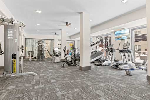 A gym with a variety of exercise equipment and a treadmill at Aster Apartments, Ohio, 44122